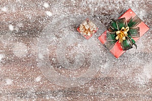 Two ted gift boxes on wood background and blurry out focus snow