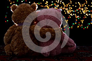 Two Teddie bear sitting holding bokeh background