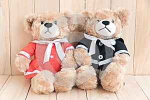 Two teddy bears on wood background