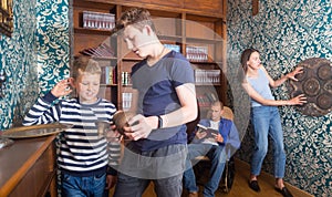 Two teen brothers examining ancient kettle in quest room