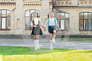 two teen children in uniform walking together outdoor