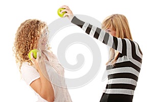 Two teen girlfriends eating green apples