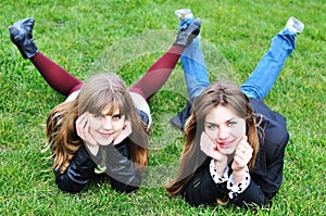 Two teen girls laying on the grass