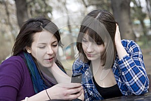 Two teen girls reading sms-text