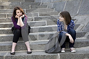 Two teen girls sitting on stairs