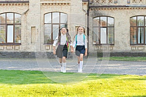 two teen girls in uniform walking together outdoor