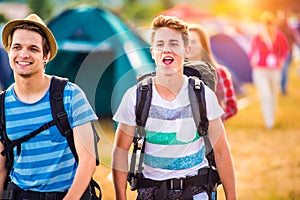 Two teenage boys with backpacks arriving at music festival