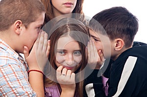 Two teenage boys and girl gossiping