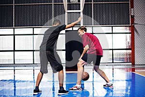 Two teenage boys playing basketball together on the court