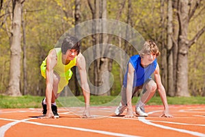 Two teenage boys ready to start running on a track