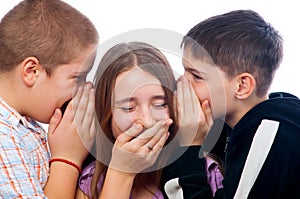 Two teenage boys telling jokes to teenage girl photo