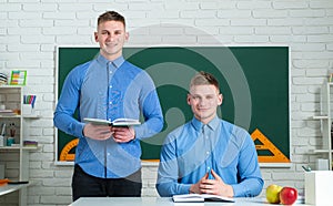 Two teenage boys twins in school dress with books. Brother support. Twin boys in uniform on lesson. Brothers in college