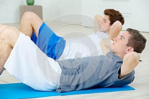 Two teenage friends doing sit ups