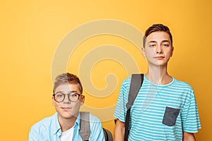 Two teenage friends, one guy humiliates the other, popular humiliates the unpopular, on a yellow background photo