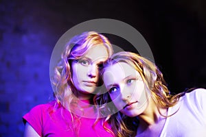 Two teenage girls on blue background looking up