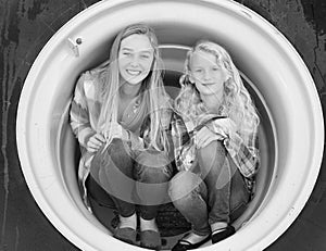 Two teenage girls crouched in tractor tire