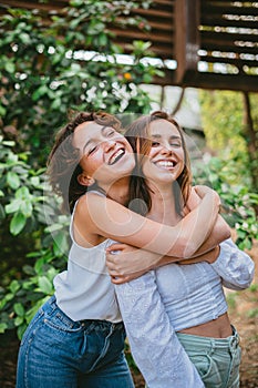 Two teenage girls hugging and laughing