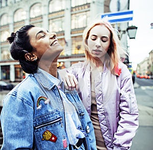 Two teenage girls infront of university building smiling, having