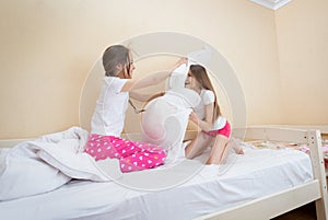 Two teenage girls in pajamas having fun and fighting with pillow