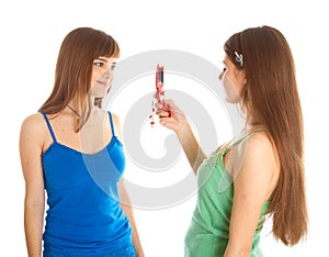 Two teenage girls photographing on mobile phone