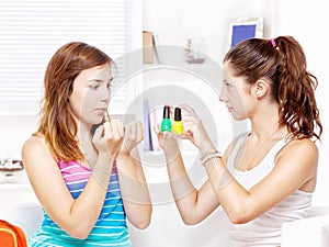 Two teenage girls polishing fingernails