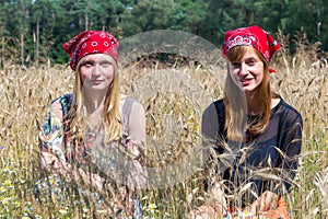 Two teenage girls sitting in corn field