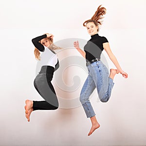 Two teenage girls smiling and jumping friends