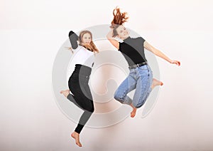 Two teenage girls smiling and jumping friends