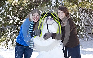 Two teenage girls with snowman