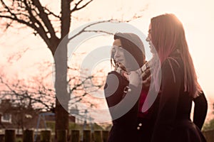 Two Teenage Girls Standing Outside at Sunset
