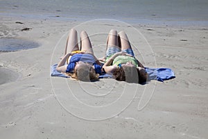 Two Teenage Girls Sunbathing at the Beach