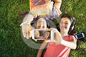 Two Teenage Girls Taking Selfie In Park