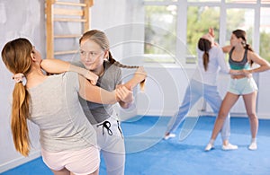 Two teenage girls training in group self defense classes