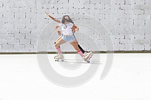 Two teenage Latin girls dressed in shorts and white t-shirt dance fun on four-roller skates