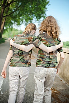 Two teenaged friends in camouflage t shirts