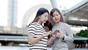 Two Teenager travellers checking location map on smartphone
