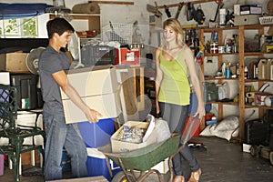 Two Teenagers Clearing Garage For Yard Sale