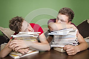 Two teenagers sleeping on books