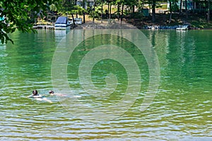 Two teens swimming in the lake