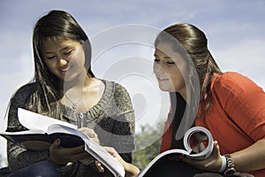 Two teens or young women studying