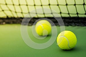 Two tennis balls on green court