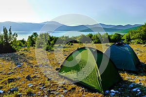 Two tents during sunrise on the rocky ground. photo