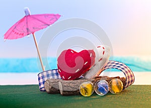 Two textile hearts sit on a log on the seashore