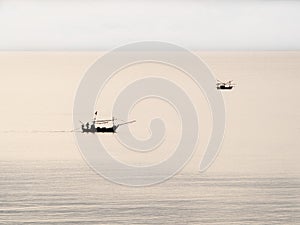 Two thai fisherman boat in the cloudy evening sea