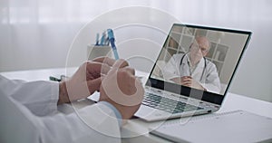 Two therapists are consulting online to each other by videoconference from their offices in clinics, elderly doctor on