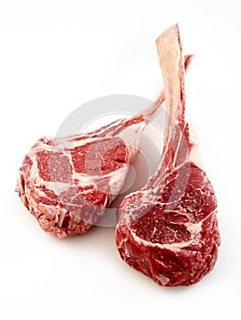 Two thick bone-in tomahawk or ribeye steaks photo