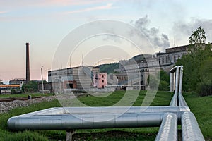 Two thick heating pipes coming from a shale plant.