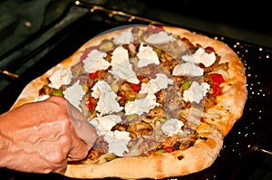 Two thirds finished, pizza and the adding of mozzarella cheese  then finished in the oven,