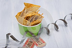 Two tickets to the cinema, under a bucket of nachos and unwrapped tape for film