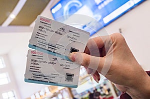 Two tickets in a woman`s hand for travel by high-speed train CRH
